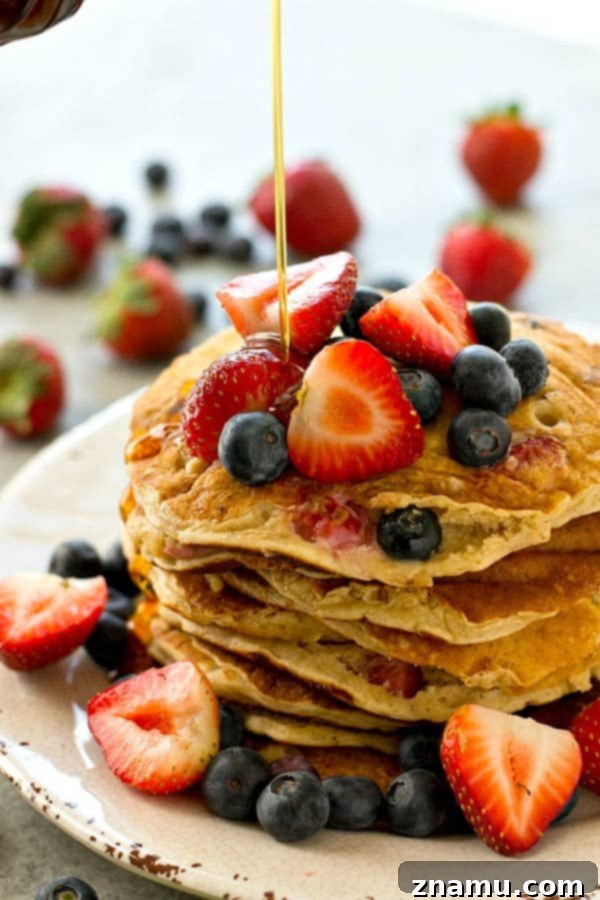 Hearty Berry Multi-Grain Pancakes 4 Close-up view of a stack of fluffy berry-filled multi-grain pancakes