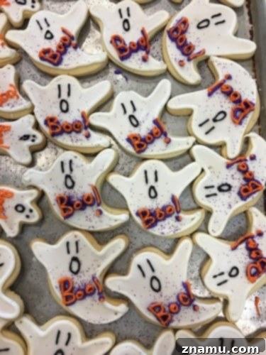 The Culinary Crucible: Volume Three 28 Close-up of a hand decorating a Halloween sugar cookie with icing