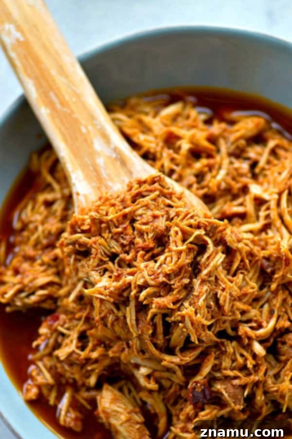 Sweet and Smoky Crockpot Chipotle Maple BBQ Chicken Sandwiches 5 Raw chicken breasts submerged in homemade chipotle maple BBQ sauce within a slow cooker, ready for cooking.
