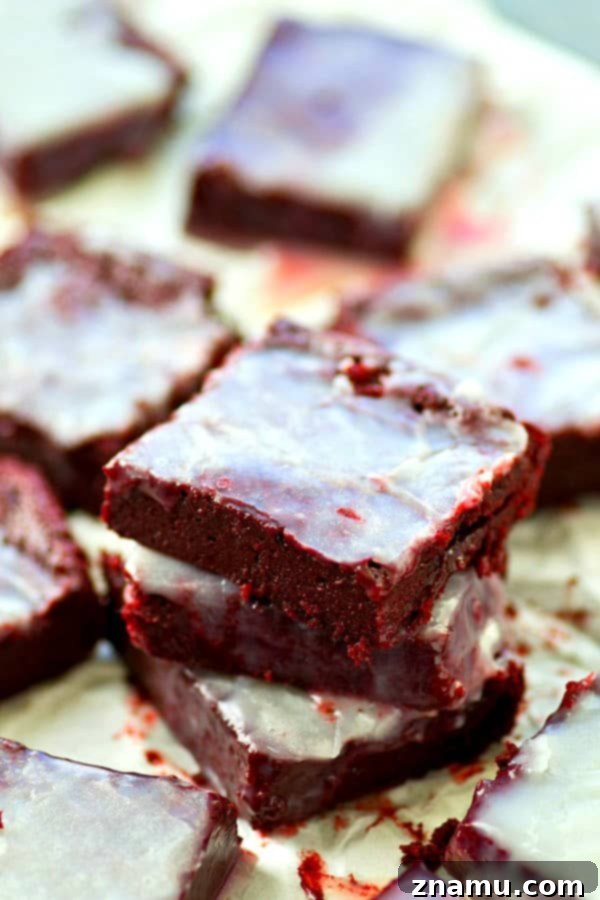 Stack of White Chocolate Red Velvet Brownie Bites drizzled with white chocolate