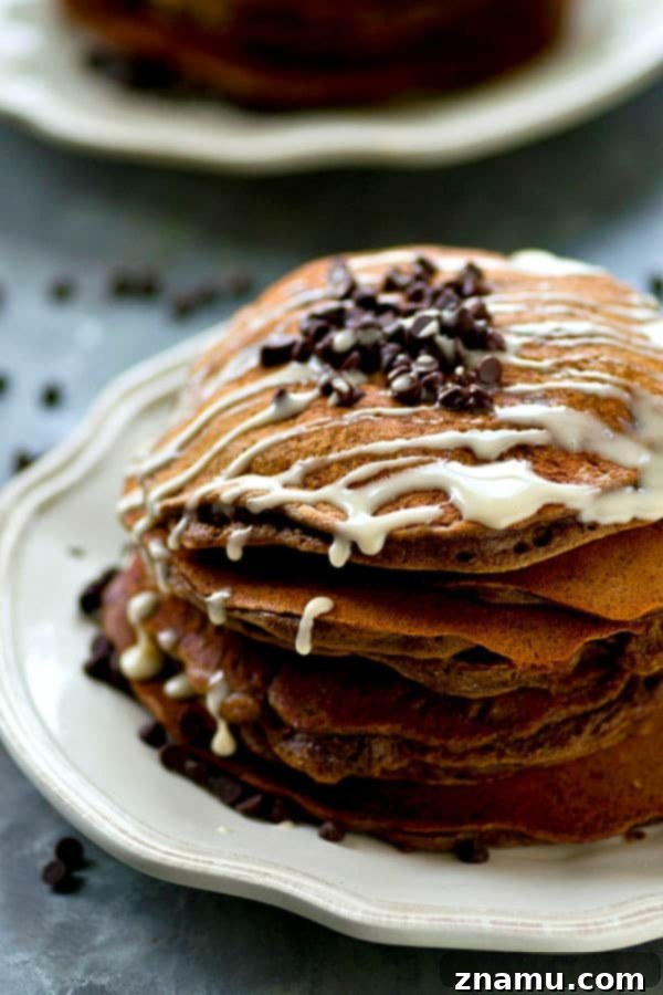 Lighter Double Chocolate Pancakes Espresso Glazed 6 A close-up of a single double chocolate pancake, showing its fluffy texture and melted chocolate chips, with espresso glaze.