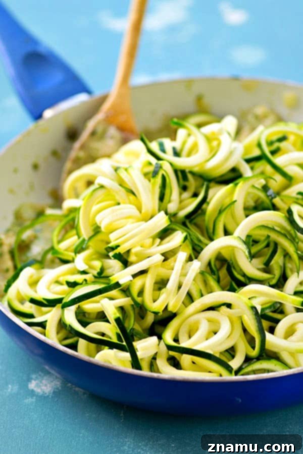 Creamy One-Pot Pesto Chicken Zoodles Alfredo 4 Serving of freshly made pesto chicken alfredo zoodles in a skillet
