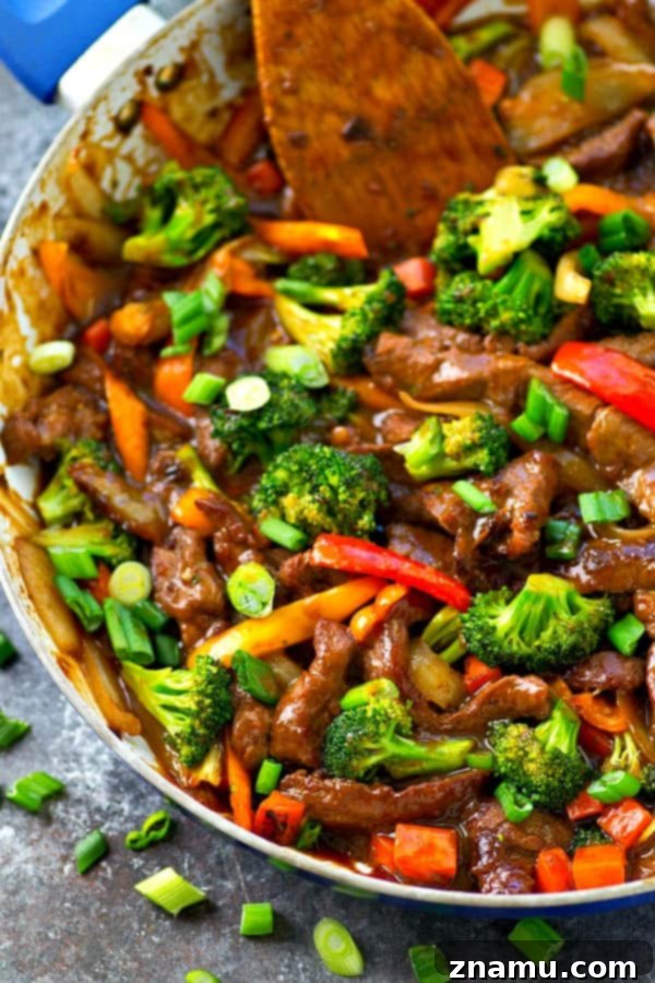 Fast Skillet Mongolian Delight 3 Close-up of tender Mongolian beef slices with vibrant vegetables in a skillet, coated in a glossy sauce.