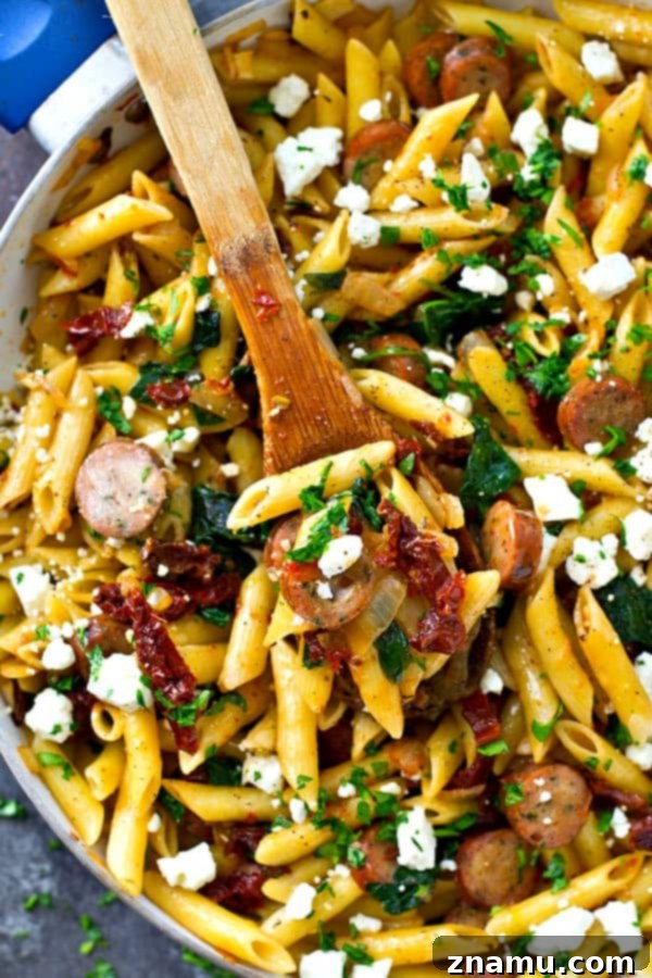 One-Pan Sun-Dried Tomato Sausage & Feta Penne 3 Close-up of a loaded Sun-Dried Tomato Penne Skillet, showing pasta, sausage, spinach, and feta cheese