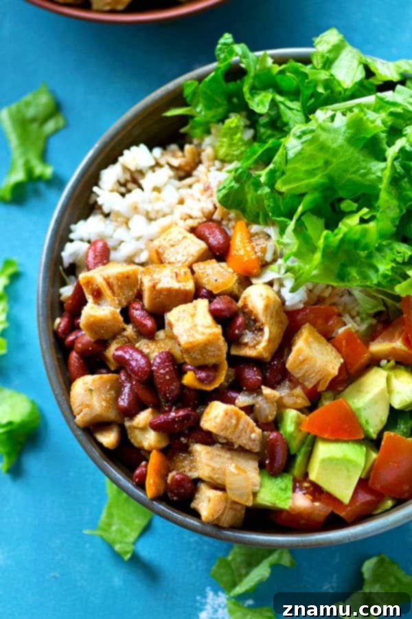 Southwest Chipotle Chicken Bowls 2 Loaded with spicy chipotle chicken and beans, fluffy hot rice, and fresh salad toppings in a vibrant bowl