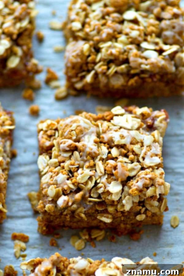 Delicious glazed peanut butter and jelly cookie bars with streusel topping on a plate.