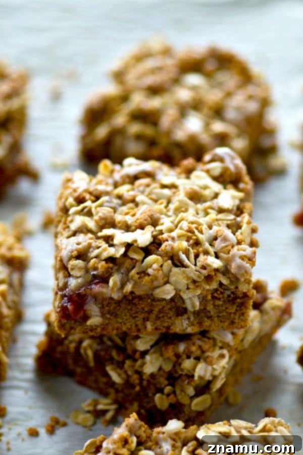 Close-up of a single peanut butter and jelly cookie bar, showcasing the jam layer and streusel.
