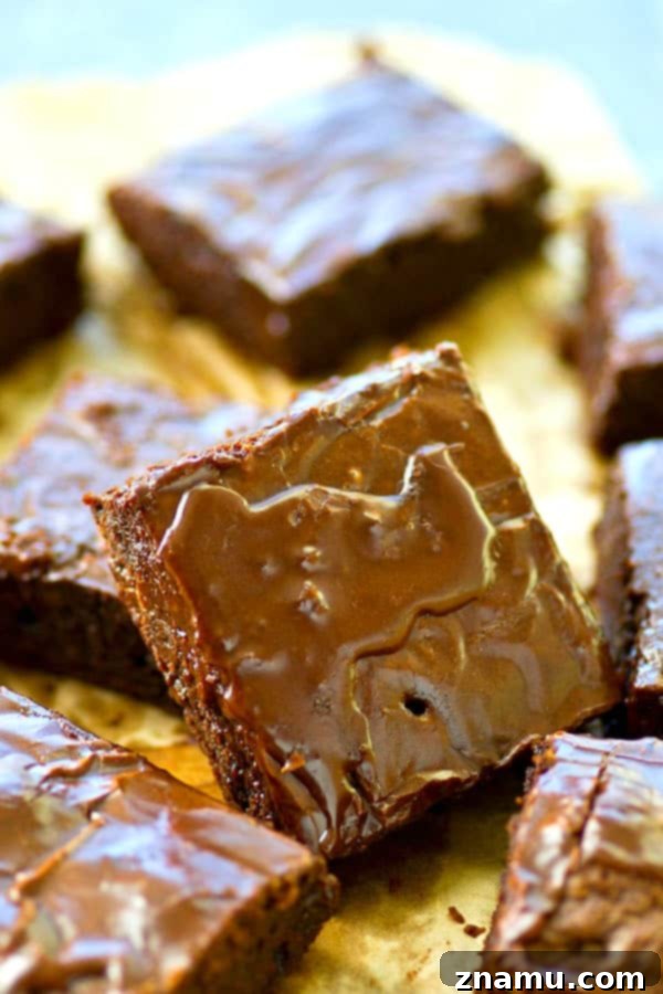 Hand reaching for a perfectly sliced mocha-glazed brownie, highlighting its appealing texture.