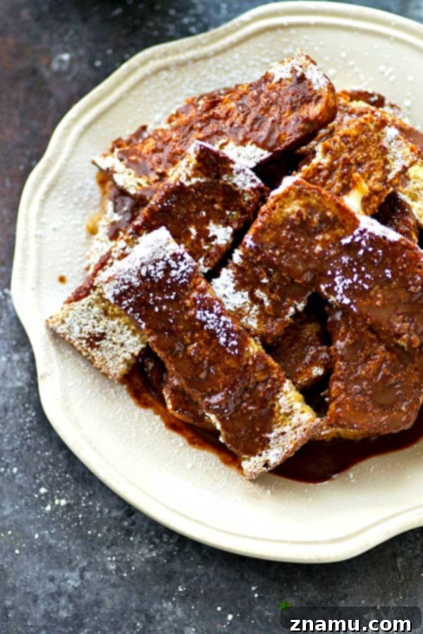Decadent Espresso French Toast Sticks with Mocha Glaze 5 French toast strips soaking in a bowl of espresso-infused egg batter