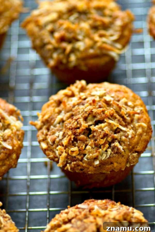 Freshly baked banana coconut streusel muffins piled high on a cooling rack, showcasing their golden streusel topping.