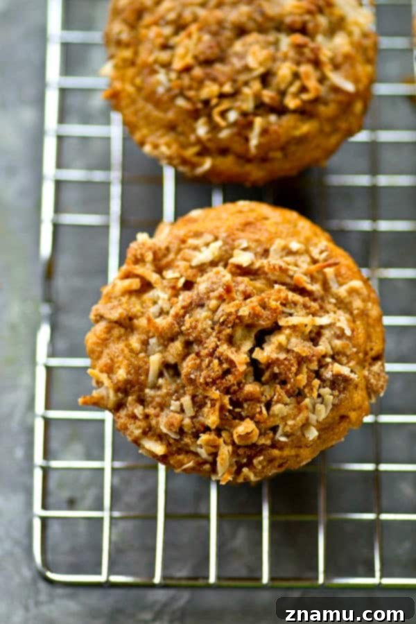 A trio of banana coconut streusel muffins, perfectly golden brown and ready to be enjoyed.