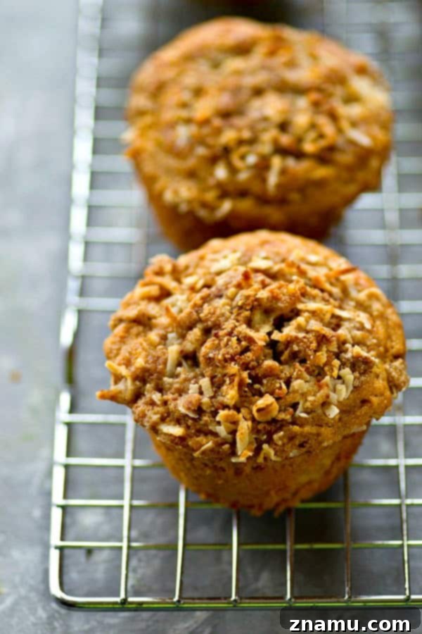 A close-up shot of a banana coconut streusel muffin, split open to reveal its fluffy texture.