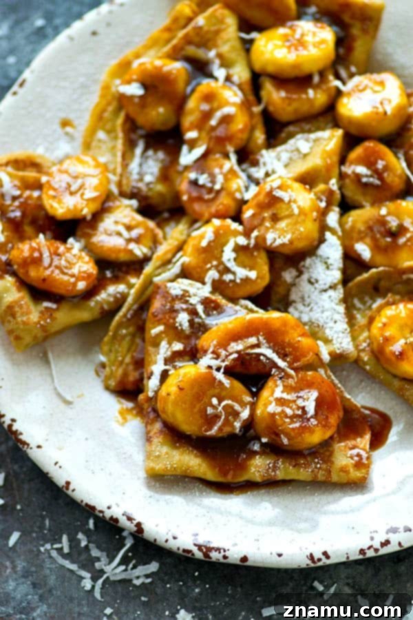Golden Coconut Crepes with Sticky Banana Caramel 6 Multiple folded coconut crepes, drenched in homemade caramelized banana sauce, showcasing the rich texture of the sauce and the tender crepes, ready to be enjoyed as a gourmet dessert