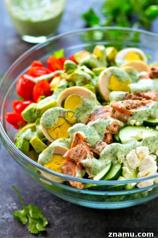 Perfectly organized Cobb Salad with an array of fresh ingredients, including grilled salmon.
