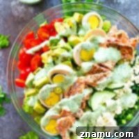 Grilled salmon, tons of fresh veggies, and an insanely flavorful cilantro lime ranch dressing make this cobb salad the ULTIMATE salad to put on the lunch or dinner rotation!