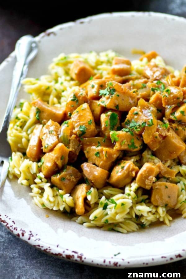 A bowl of fluffy herbed orzo pasta, an ideal companion for the savory orange chicken.