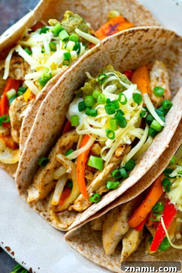 Sheet Pan Spicy-Sweet Chicken Tacos 5 Overhead shot of a platter of colorful sheet pan chicken and sweet pepper tacos with various toppings.