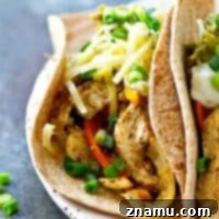 Close-up of a loaded sheet pan chicken and sweet pepper taco.