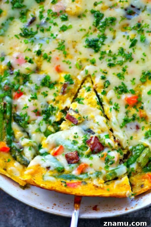 Swiss Cheese, Asparagus, and Bacon Frittata 5 The cooking process of the frittata, showing the egg mixture poured over the sautéed asparagus, bacon, and red pepper in a cast-iron skillet.