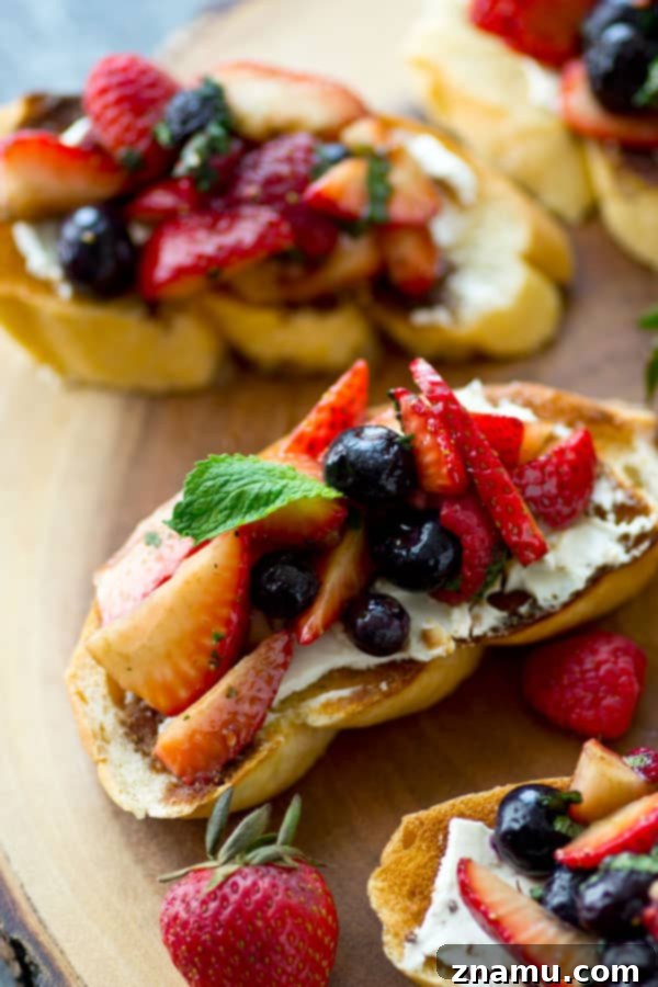 Sunrise Berry Cream Cheese Bruschetta 2 A beautifully presented mixed berry cream cheese breakfast bruschetta, showcasing toasted bread, creamy cheese, and a medley of fresh blueberries, raspberries, and sliced strawberries. Ideal for a festive brunch.