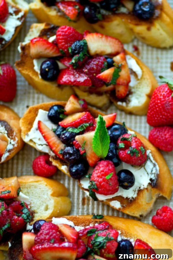 Sunrise Berry Cream Cheese Bruschetta 3 Close-up shot of a single piece of mixed berry cream cheese breakfast bruschetta, highlighting the texture of the toasted bread, the smooth cream cheese, and the juicy, colorful berries.