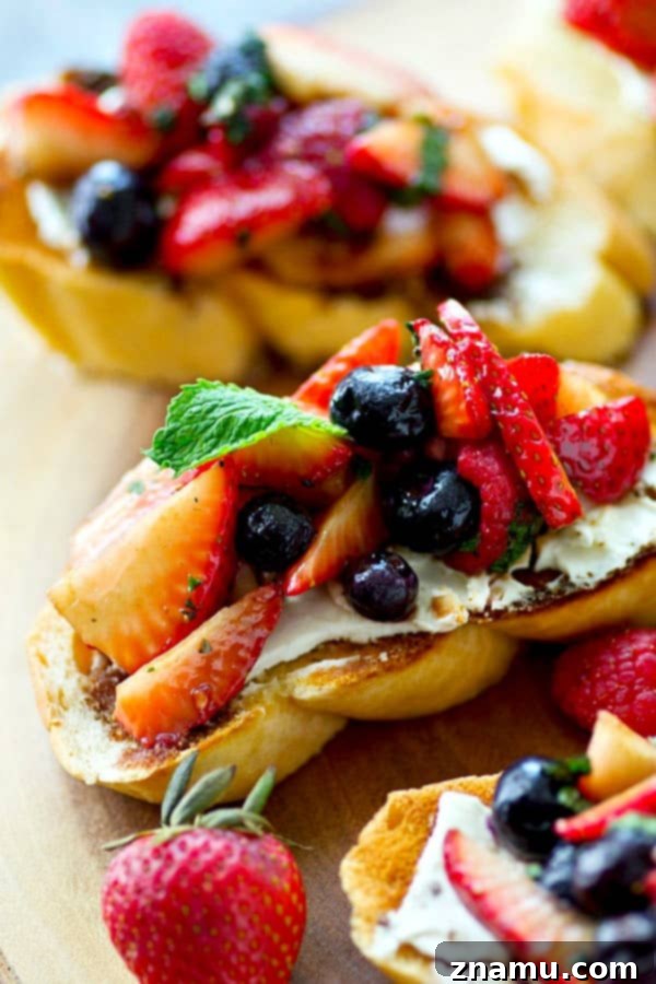Sunrise Berry Cream Cheese Bruschetta 5 A close-up of a single bruschetta piece, showing the thick layer of cream cheese under a generous topping of mixed berries, ready to be devoured.