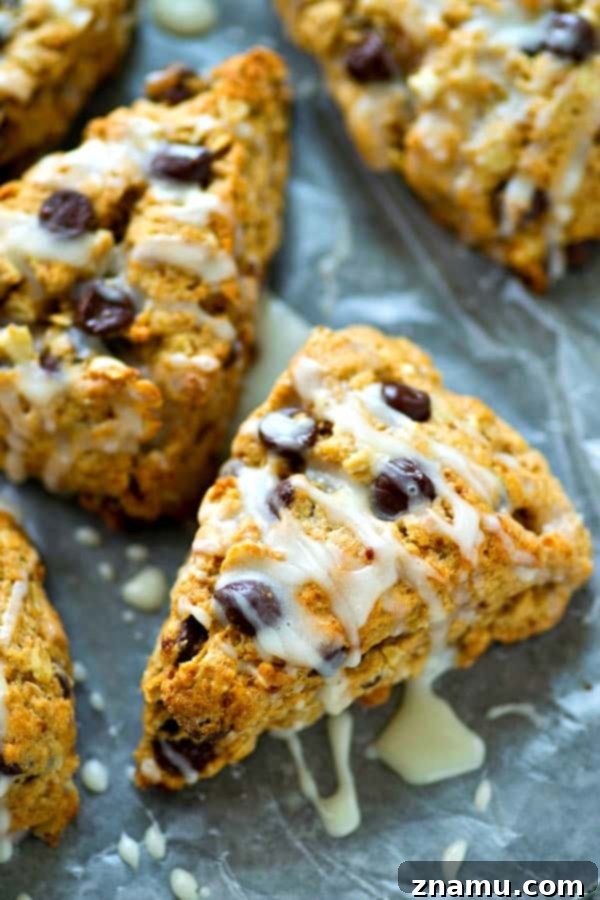 Glazed Chocolate Chip Oatmeal Scones 6 A stack of golden Oatmeal Chocolate Chip Scones with vanilla glaze