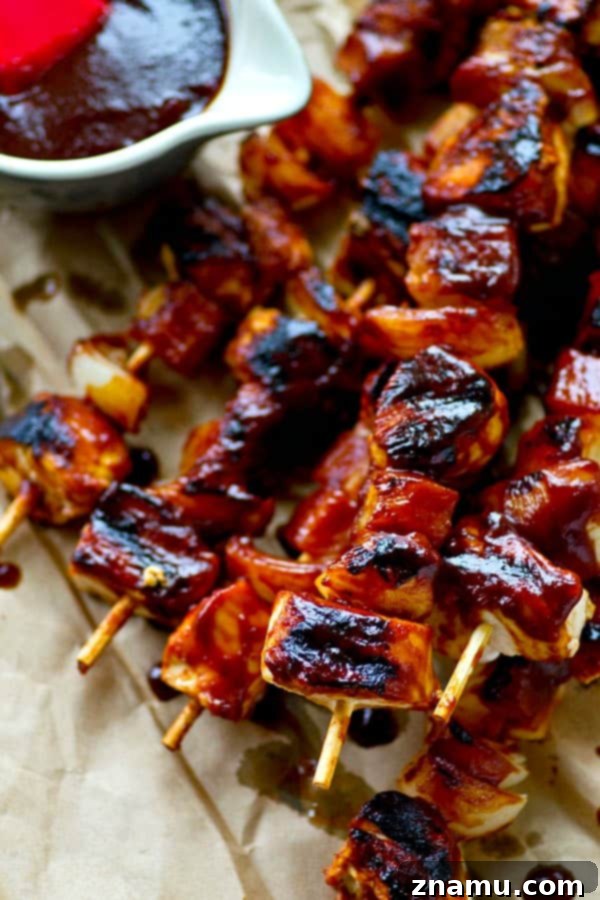 Aloha Chicken Kebabs 6 Cooking Hawaiian BBQ Chicken Kebabs on the grill, brushing with sauce.