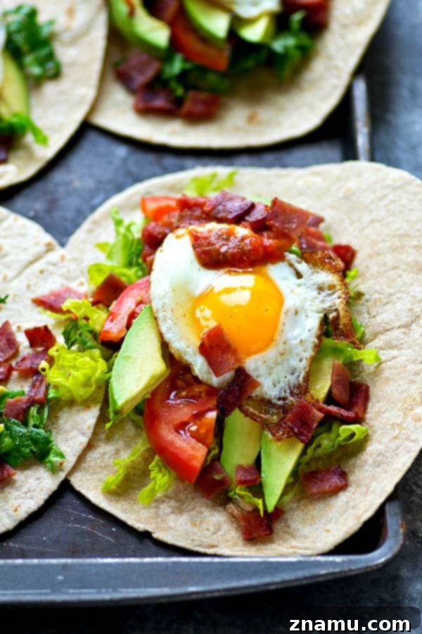 Crispy BLT Tostadas with Fried Egg and Fresh Avocado 3 A close-up of a single BLT Fried Egg Avocado Breakfast Tostada, highlighting the vibrant green avocado, red tomato, and perfectly cooked egg.