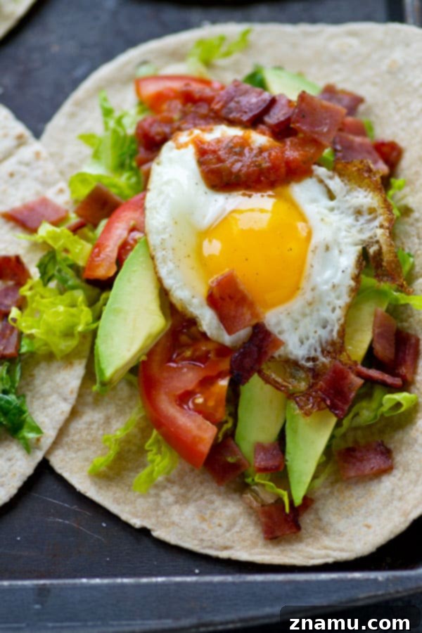Crispy BLT Tostadas with Fried Egg and Fresh Avocado 6 Multiple BLT Fried Egg Avocado Breakfast Tostadas arranged attractively on a wooden surface, ready to be served.