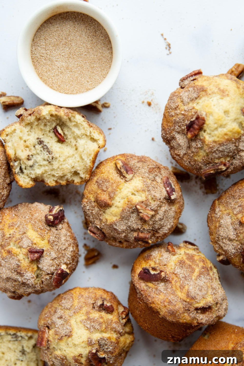 Delicious Pecan Snickerdoodle Muffins 6 A beautifully presented stack of Pecan Snickerdoodle Muffins on a plate, paired with a steaming cup of coffee, perfect for a cozy morning.