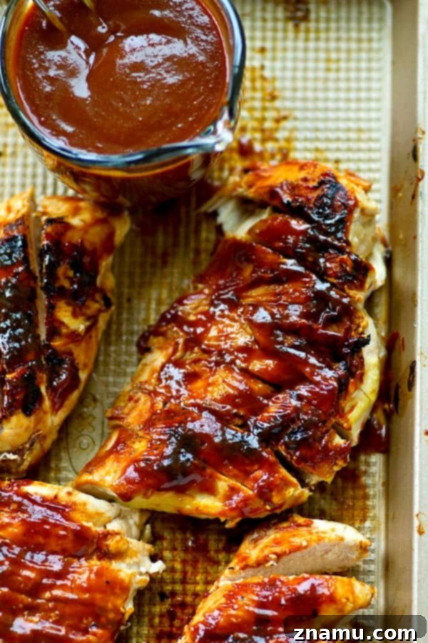 Sun-Kissed Mango BBQ Chicken 2 Juicy grilled chicken breasts coated in vibrant mango BBQ sauce, ready for a summer meal