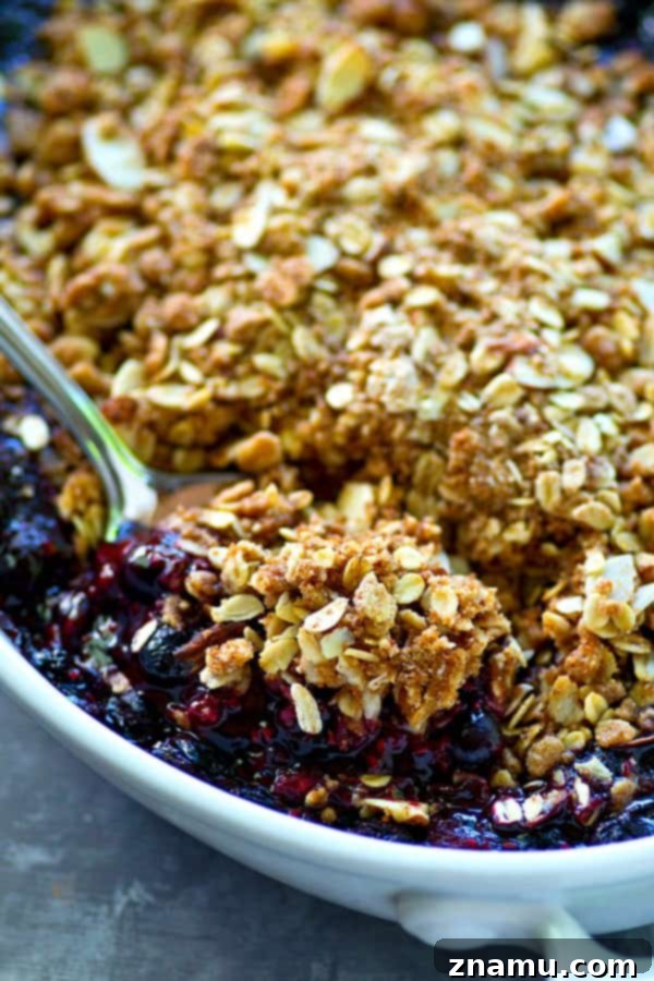 Sunshine Berry Streusel Crumble 6 A large amount of buttery streusel topping, made with oats and almonds, generously sprinkled over the cooked berry filling in a baking dish.