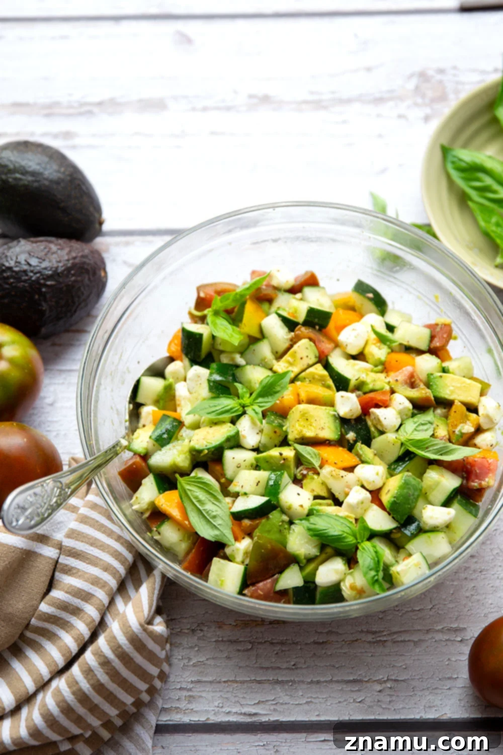 Classic Italian Tomato Cucumber Salad 5 Freshly cut tomatoes, avocados, and cucumbers, highlighting the quality of ingredients before being mixed into the salad.