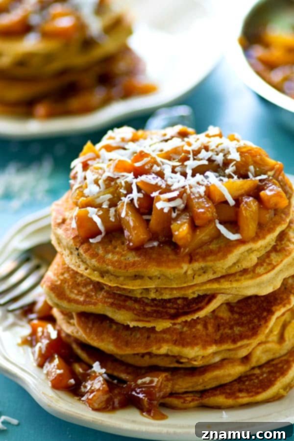 Coconut Cloud Pancakes with Zesty Orange-Pineapple Compote 5 A spoonful of chunky orange pineapple compote, showcasing its fresh ingredients and tropical aroma.