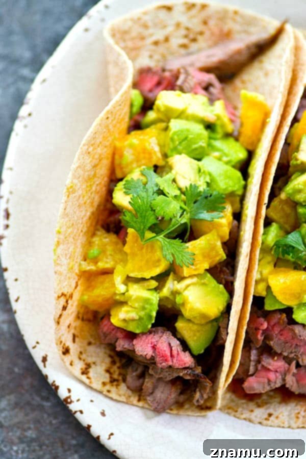Close-up of the fresh ingredients for orange avocado salsa: diced oranges, avocado, red onion, and cilantro.