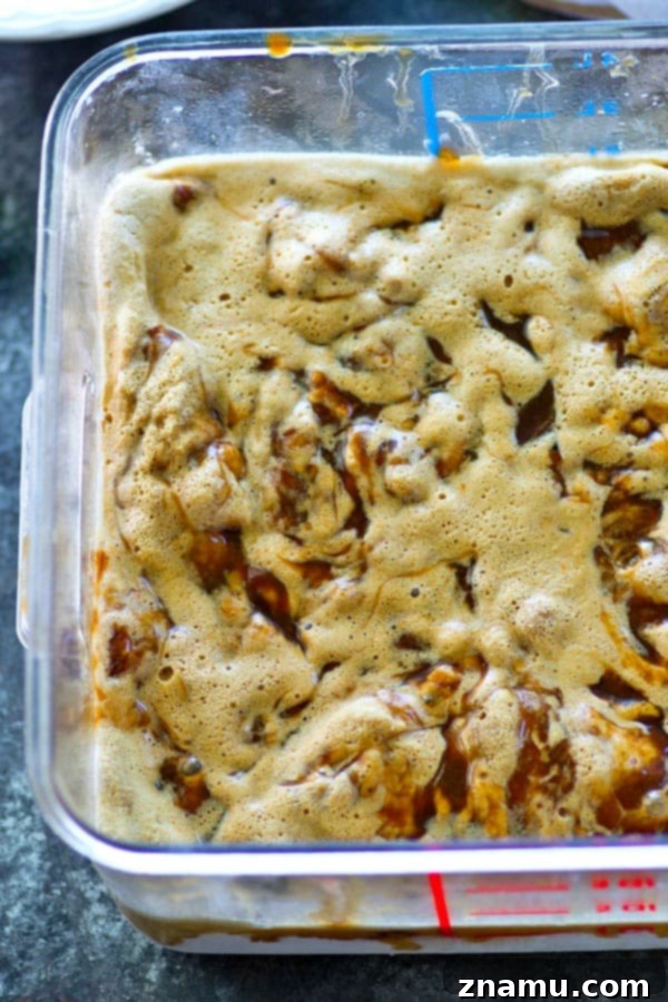 Scoops of homemade caramel macchiato ice cream in a bowl, showcasing its rich texture and the beautiful caramel swirls.