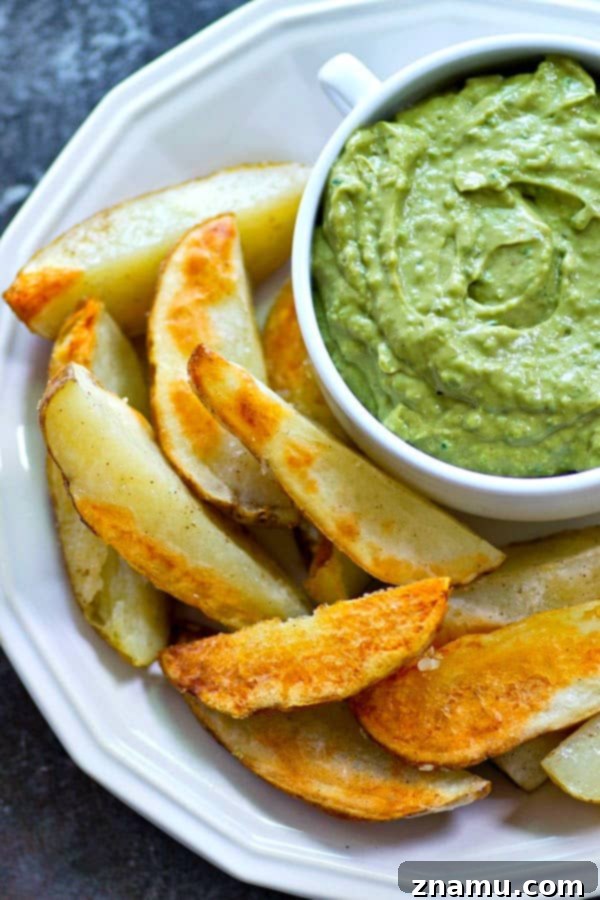 Golden Crispy Wedges with Creamy Poblano Avocado Ranch 3 Close-up view of perfectly golden and crispy oven-baked potato wedges on a baking sheet