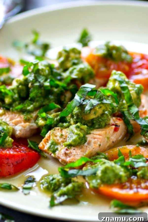 Grilled Salmon with a Medley of Heirloom Tomatoes and Zesty Avocado Chimichurri 2 Grilled salmon with vibrant avocado chimichurri sauce and colorful heirloom tomatoes, a healthy and easy summer dinner.