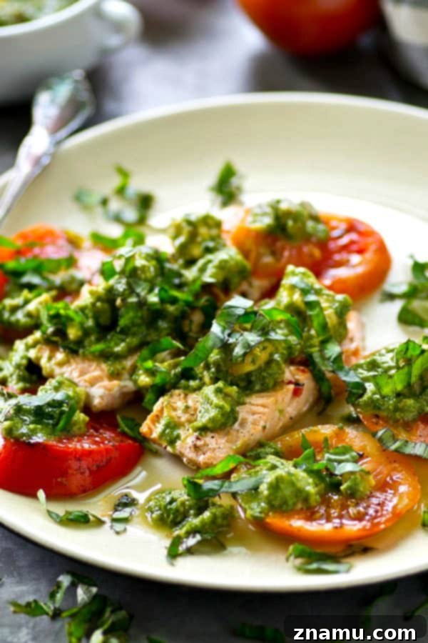 Grilled Salmon with a Medley of Heirloom Tomatoes and Zesty Avocado Chimichurri 4 A serving of grilled salmon and heirloom tomatoes topped generously with green avocado chimichurri.
