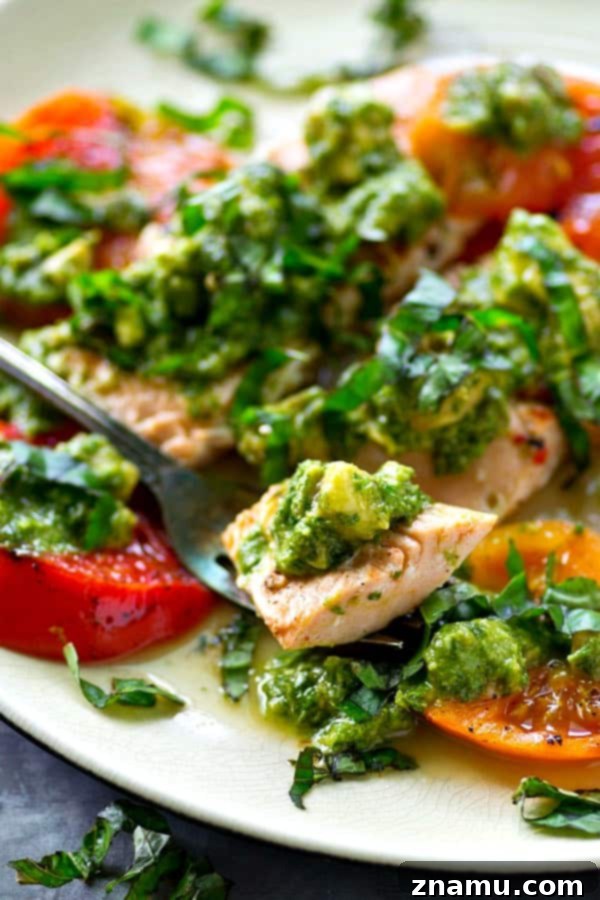 Grilled Salmon with a Medley of Heirloom Tomatoes and Zesty Avocado Chimichurri 6 A close-up of the grilled salmon and heirloom tomatoes, generously covered with fresh avocado chimichurri sauce.