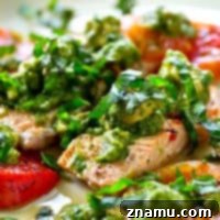 Grilled salmon and juicy heirloom tomatoes are covered in an INSANELY flavorful avocado chimichurri sauce for an easy, healthy, and flavor-packed summer dinner!