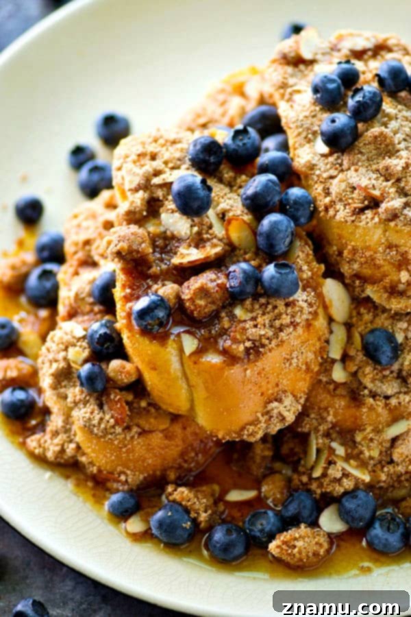 Decadent Baked Almond Streusel French Toast 2 Golden brown baked almond streusel French toast slices on a sheet pan, ready for serving.