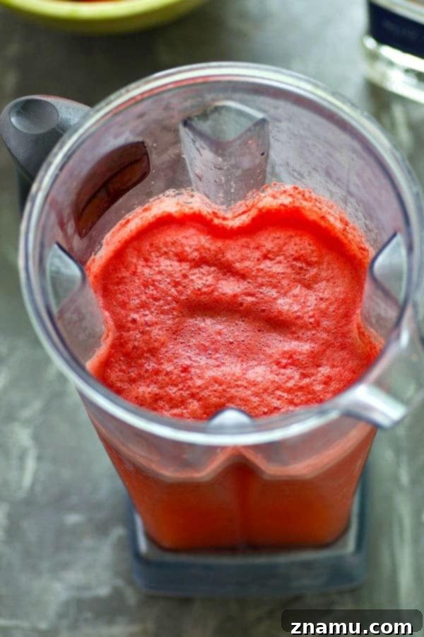 Bubbly Watermelon Lime Margarita Slush 3 Close-up shot of a frosty Sparkling Watermelon Lime Margarita Slushie, showcasing its appealing texture and bright color, promising a cool and flavorful experience.