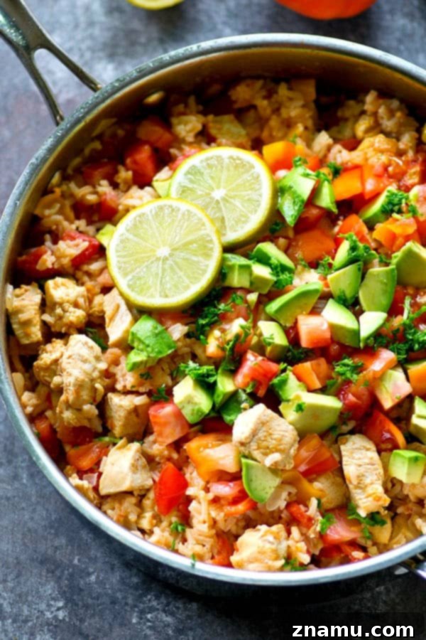 Fiesta Chicken and Rice Skillet 2 A vibrant, flavorful one-pot Mexican chicken and rice skillet, garnished with fresh toppings and ready to be served.