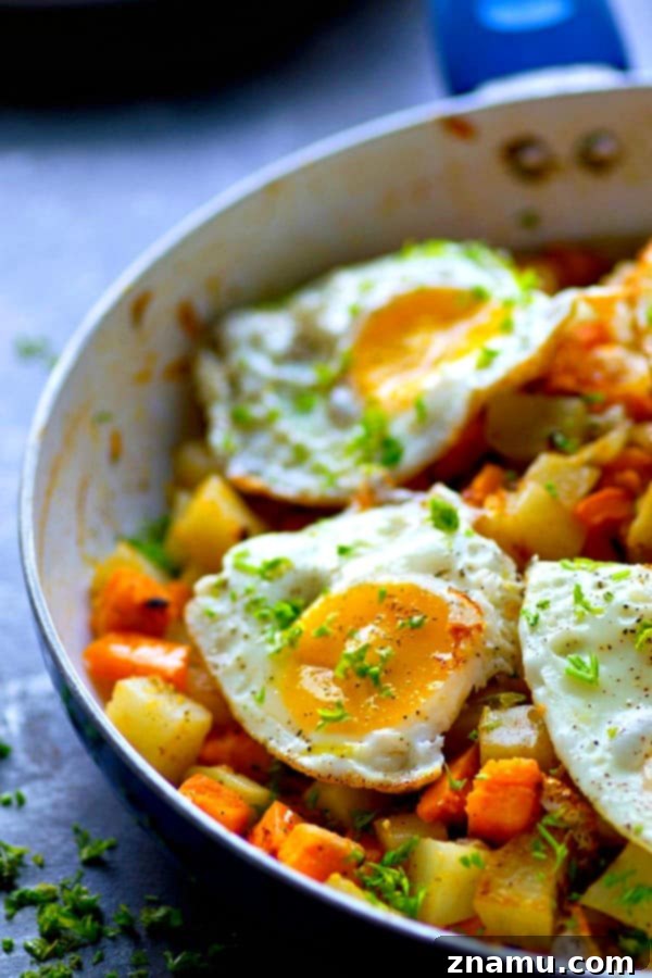 Vibrant Veggie Hash & Golden Yolks 3 A close-up of a perfectly fried egg with a runny yolk atop a colorful vegetable hash, ready to be enjoyed.