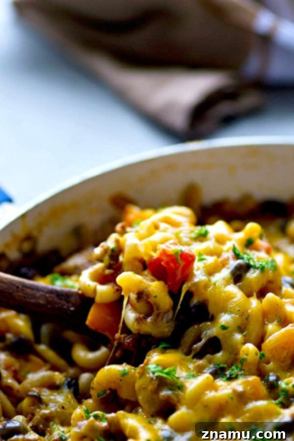 Lean Skillet Beef Chili Mac n Cheese 5 A large pot of Lighter One-Pot Beef Chili Mac and Cheese, garnished with fresh parsley, ready to be served directly from the pot.