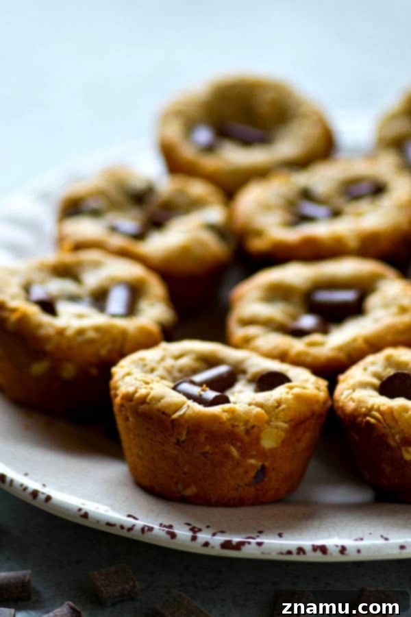 Peanut Butter Oatmeal Chocolate Chunks Cookie Cups 3 Freshly baked Peanut Butter Oatmeal Chocolate Chunk Cookie Cups in a muffin pan