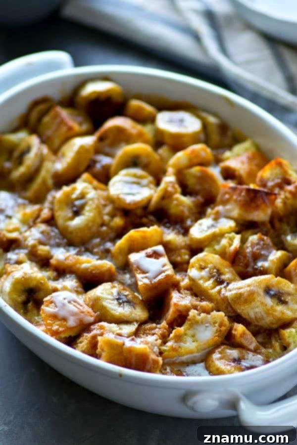 Banana-Kissed Glazed Cinnamon Roll Pudding 3 Close-up of the cinnamon swirl and banana slices within the bread pudding, topped with a creamy glaze.
