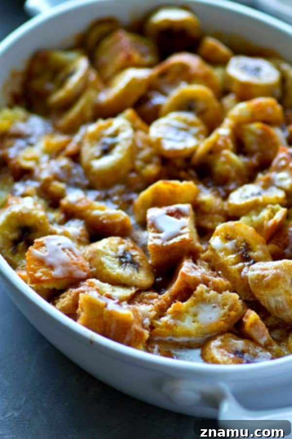 Banana-Kissed Glazed Cinnamon Roll Pudding 4 A generous serving of Glazed Banana Cinnamon Roll Bread Pudding on a plate, showcasing its golden-brown top and luscious glaze.